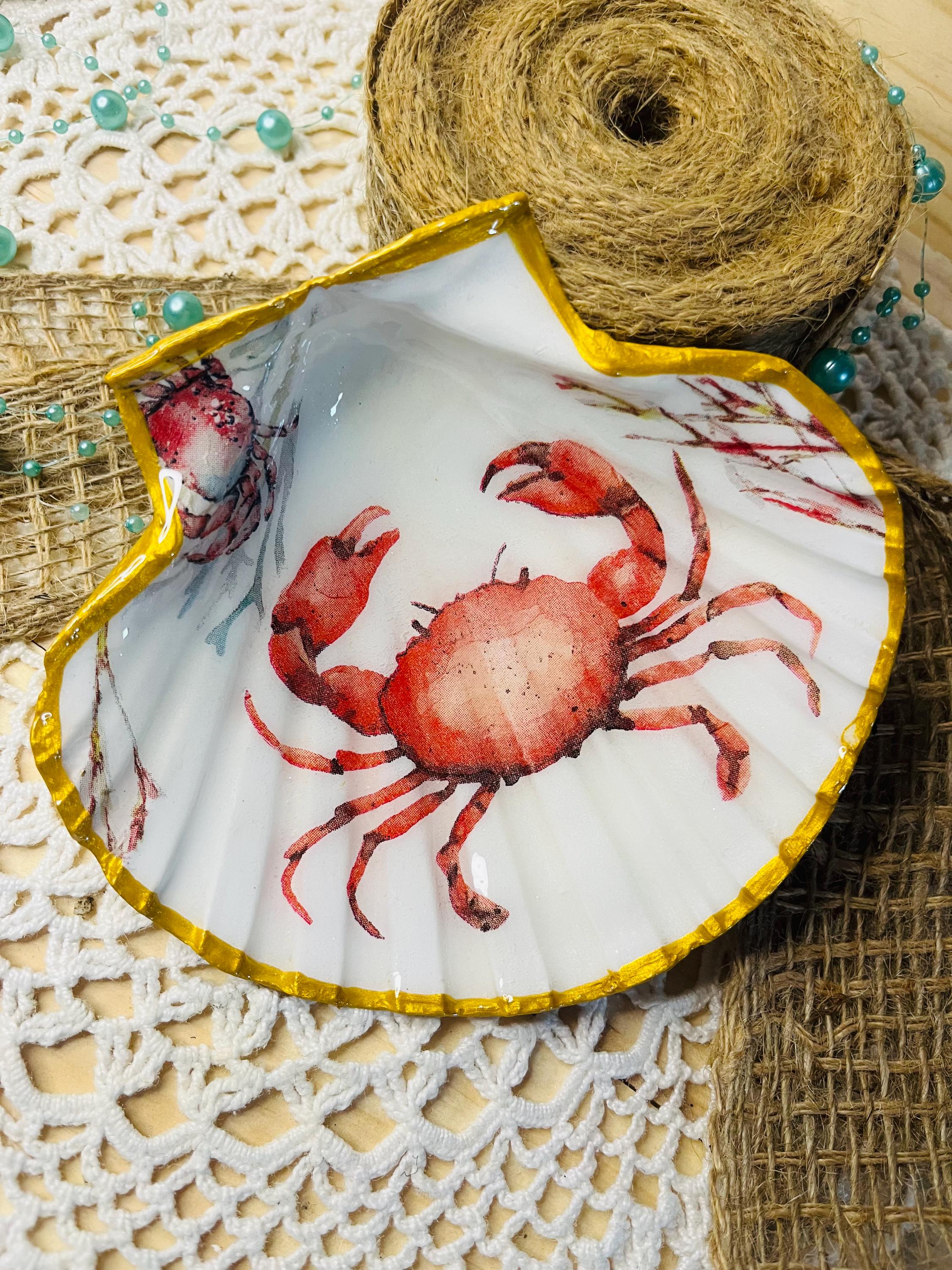 Coquille Saint-Jacques sublimée décorée d’un crabe sur fond blanc, création artisanale.