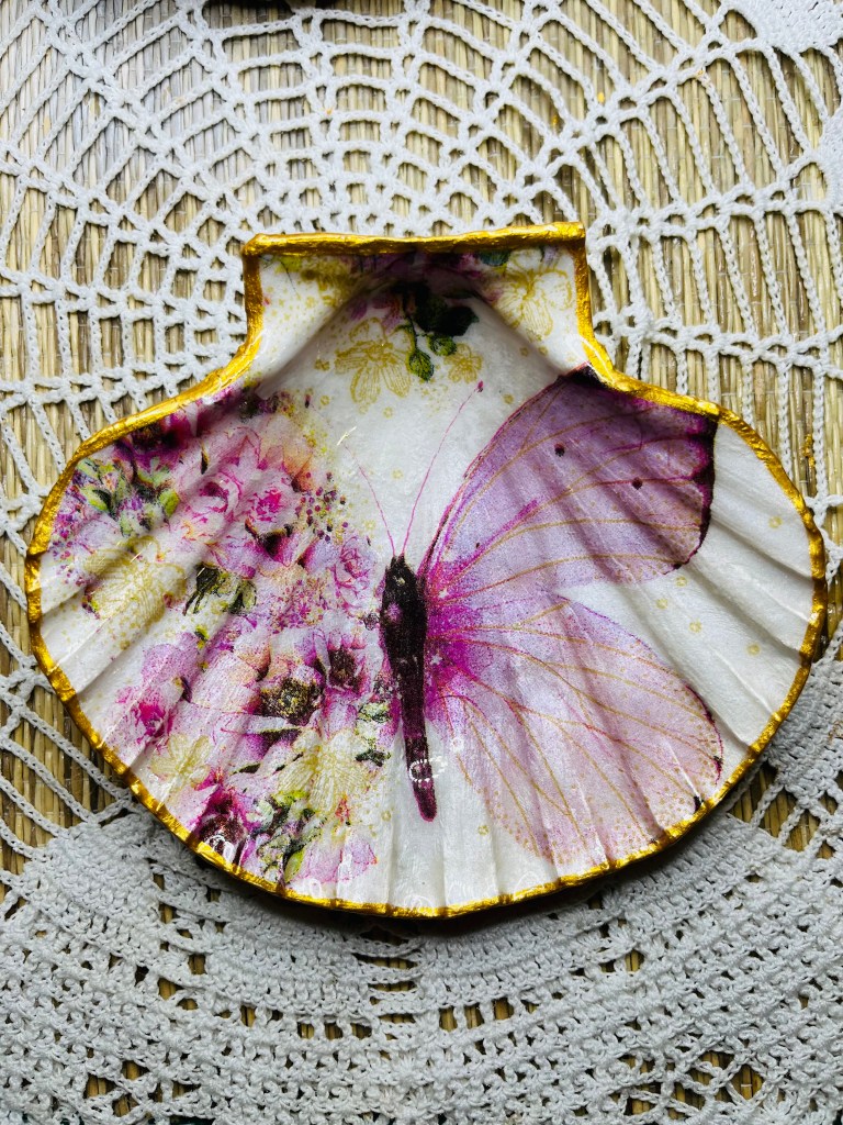 Coquille Saint-Jacques sublimée décorée d’un papillon et de fleurs rose tendre, création artisanale.